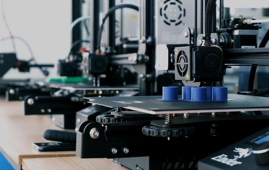3D printer printing small blue tubes