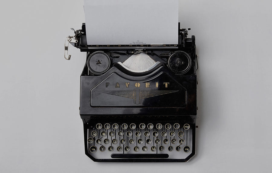 A black old typewriter on a white background